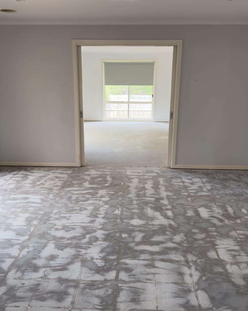 Large room after having tiles pulled up in preparation for hybrid flooring