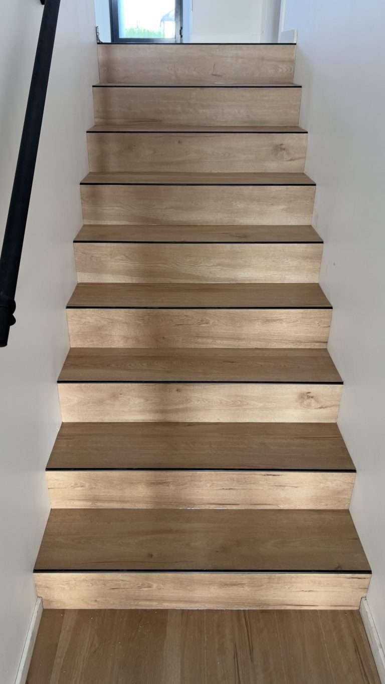 Completed vinyl plank staircase with black stair nosing and trim, professionally installed by Top Notch Flooring Warragul Gippsland